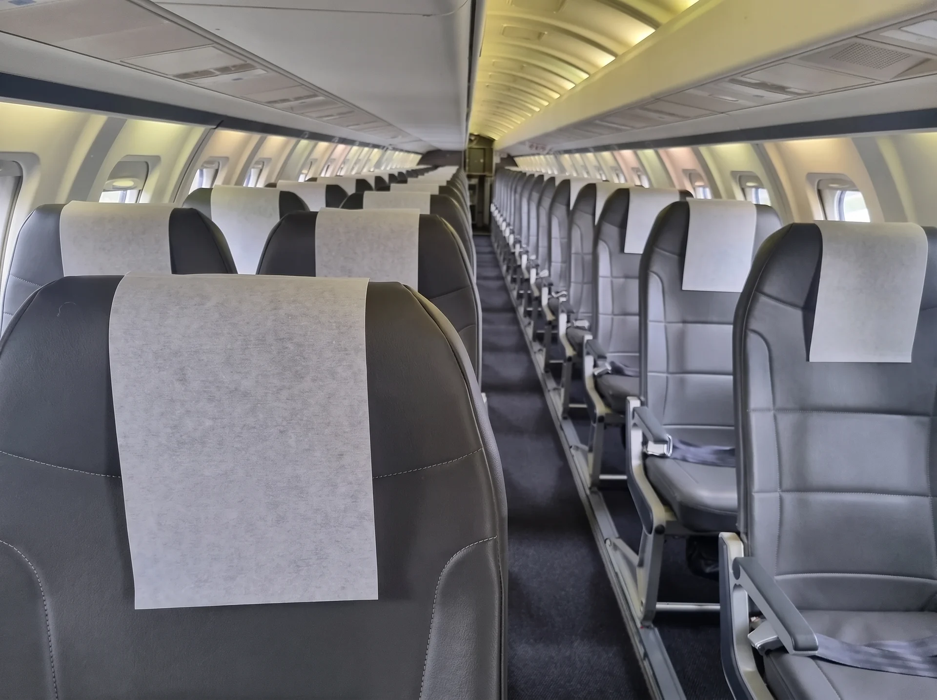 Tomma passagerarsäten i rader inuti ett flygplans kabin.